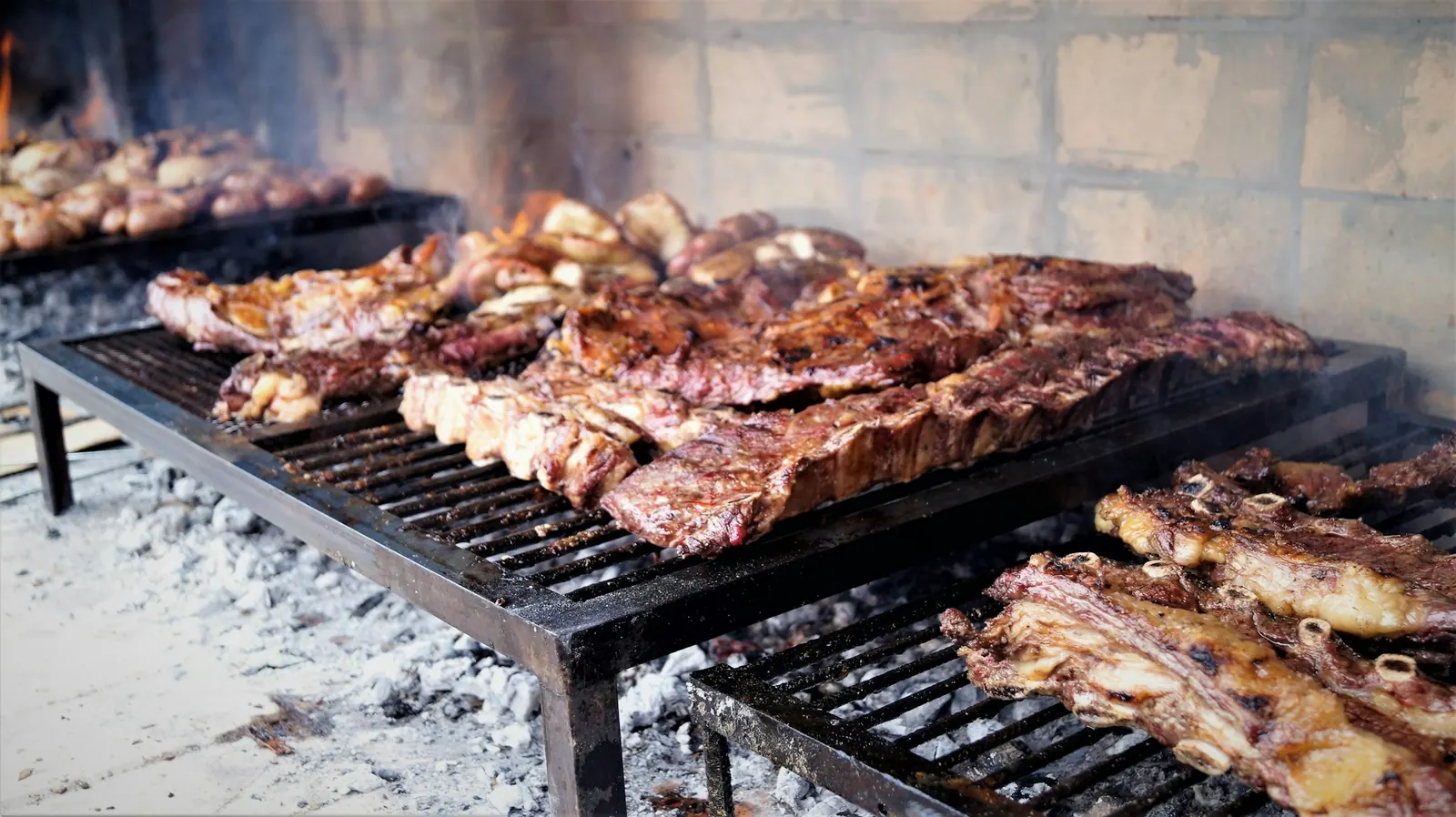 parrilla con asado de tira y cortes sobre las brasas